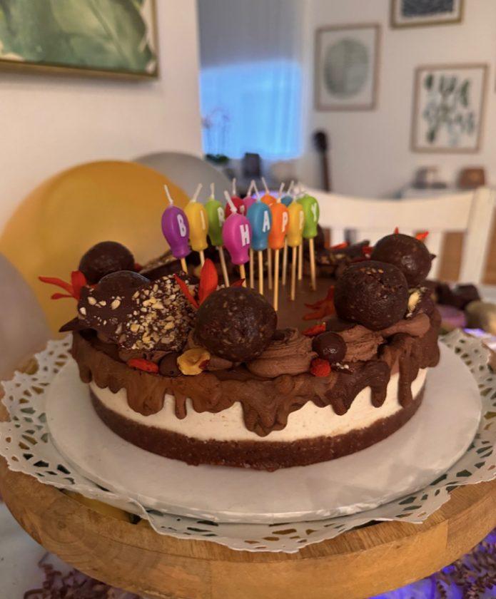 Chocolate birthday cake with colorful candles at a customer's home