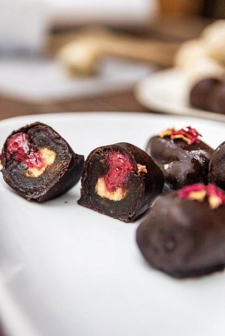 PB & Raspberry date bonbon cut in half, peanut butter and raspberry jam inside