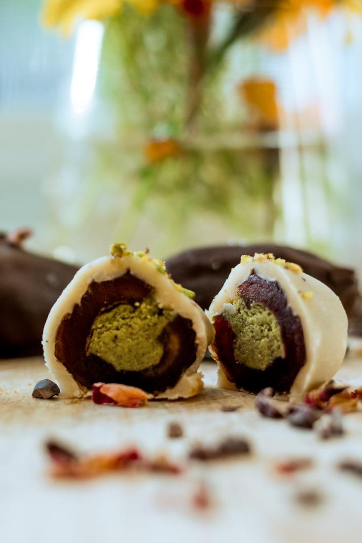 Pistachio date bonbon cut in half, white chocolate and pistachio filling