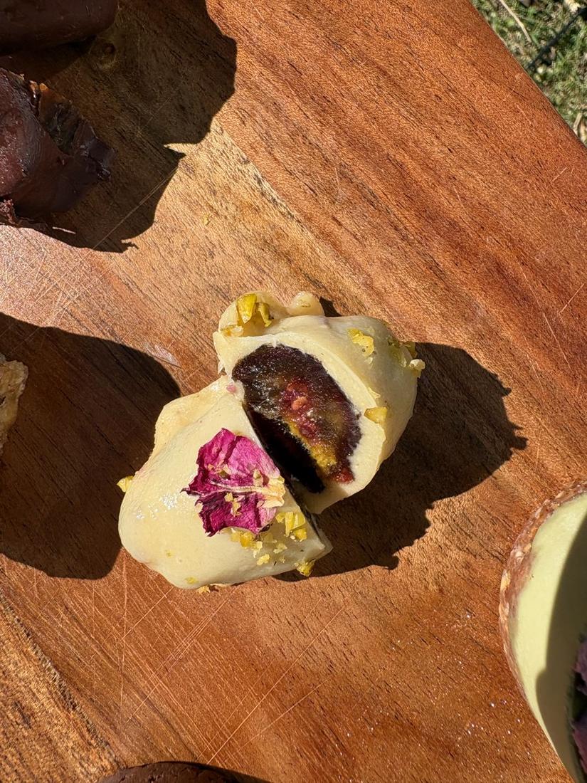 Pistachio & Raspberry date bonbon cut in half