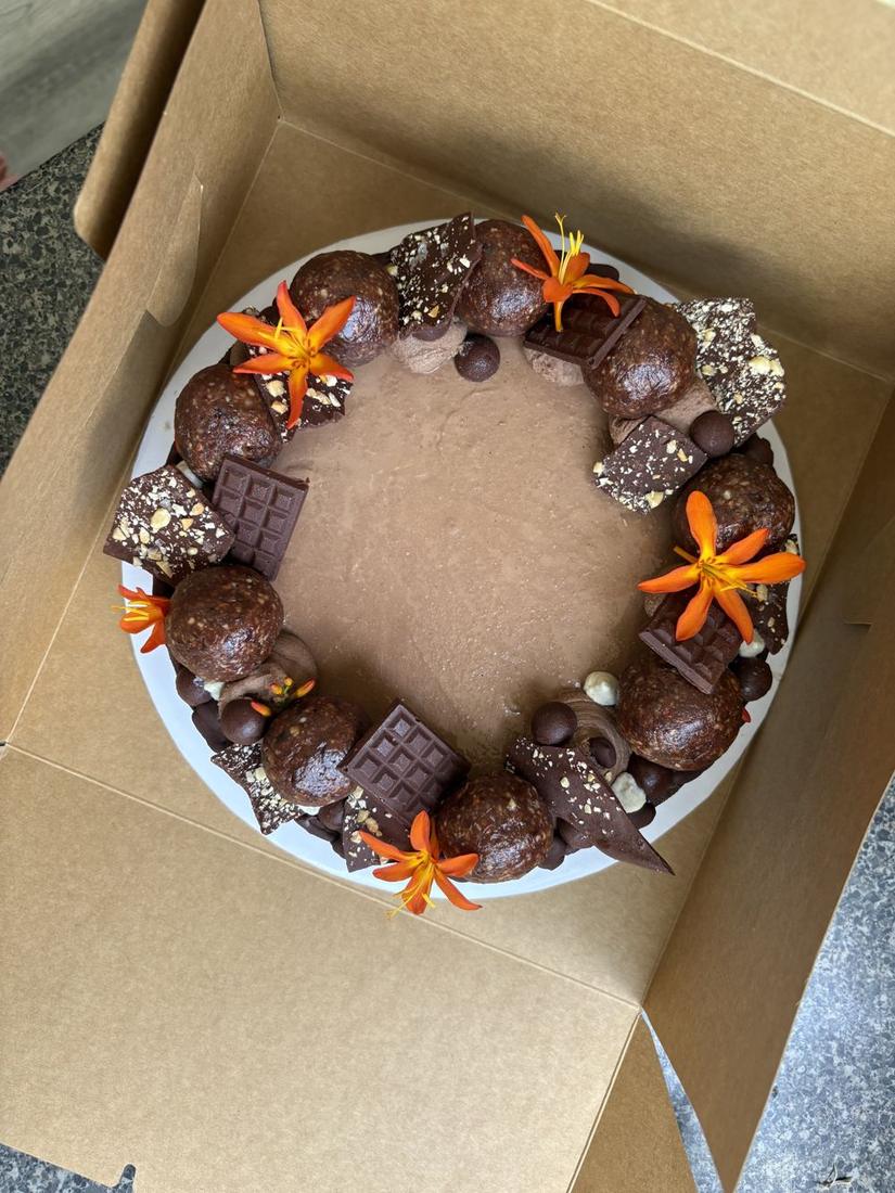 Rawtella cake from above with hazelnut cacao energy balls and orange flowers