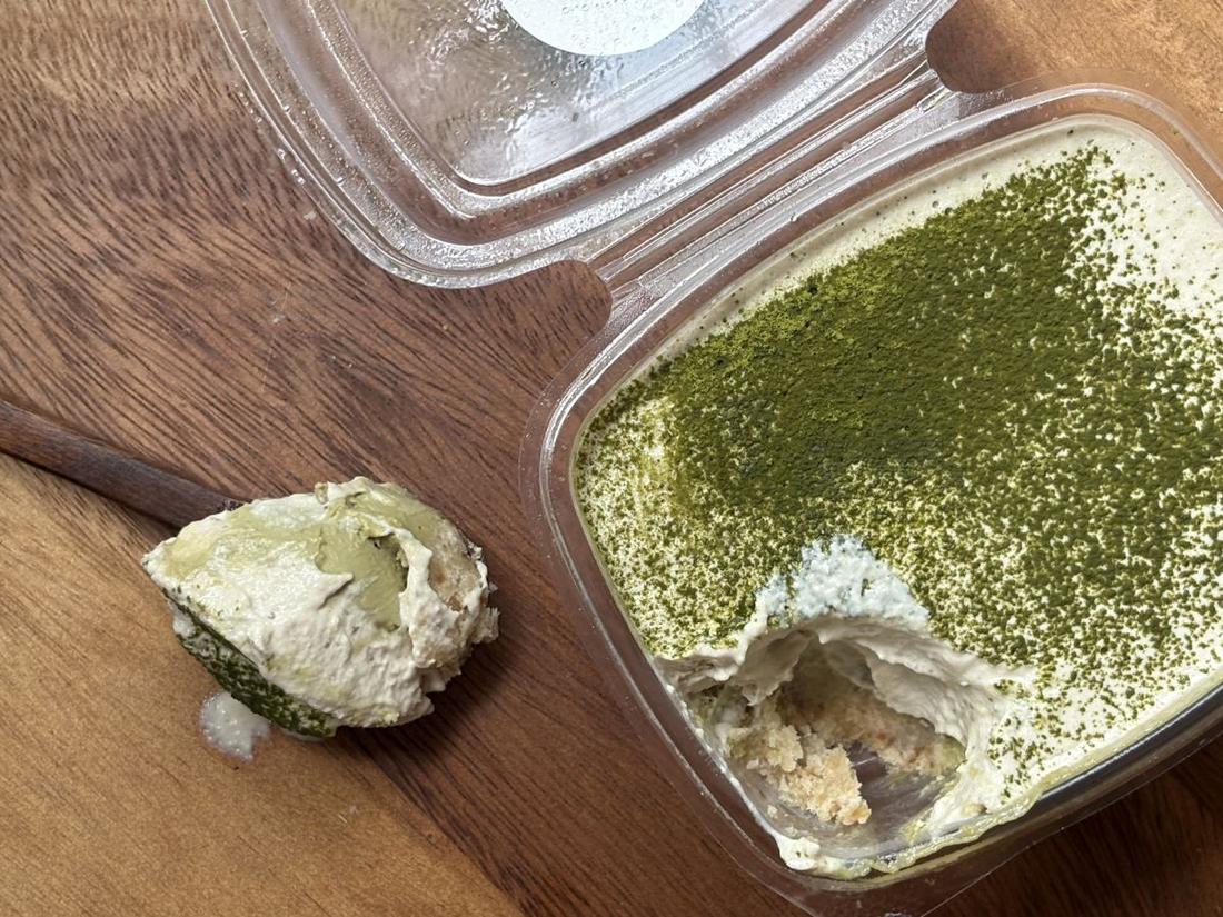 Matcha Tiramisu dusted with matcha, with a spoonful taken