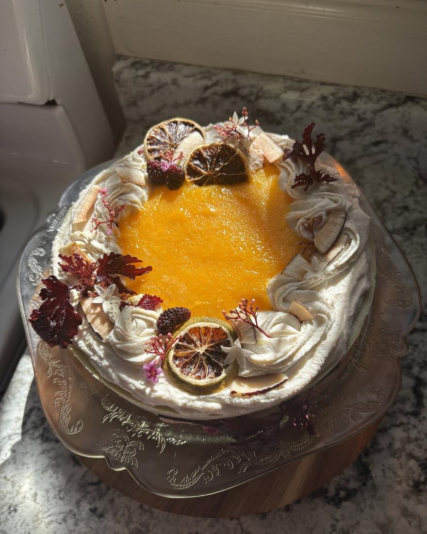 Cake with passion fruit center, dried orange slices and dark flowers